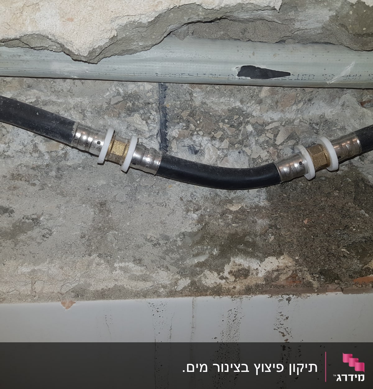 צינור שחור עם מחברים בקיר חשוף